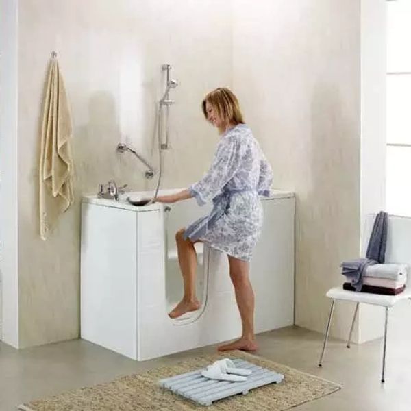 Woman using a compact, accessible shower unit in a modern accessible bathroom solutions. we also do mobility showers, walk-in showers and wet roomswe also see accessible bathroom solutions, mobility showers, wet rooms and walk-in showers / Baths
