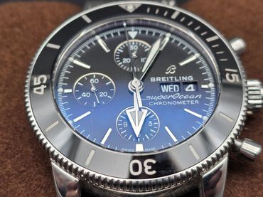 Close-up of a Breitling SuperOcean chronometer watch with a black bezel.