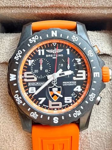 Breitling Endurance Pro watch with orange strap and Princeton University emblem.