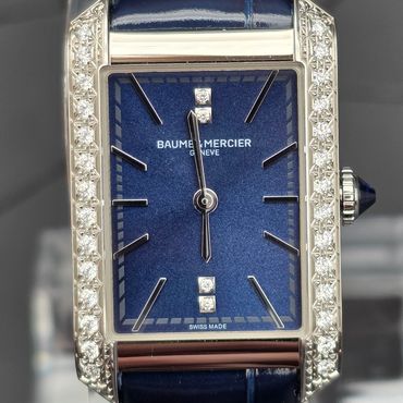 Elegant Baume & Mercier watch with blue dial and diamond-studded bezel.