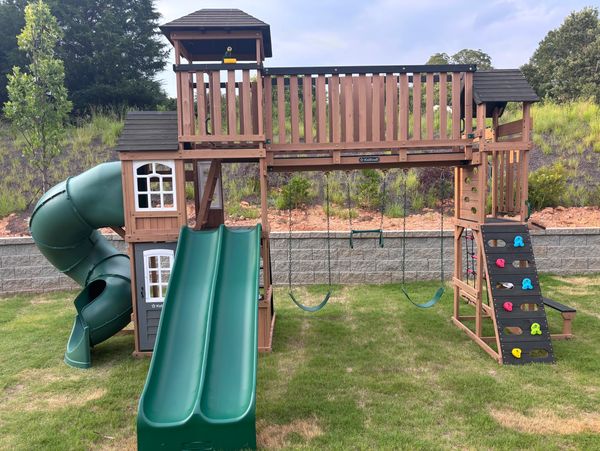 Wooden playground with slides and swings.