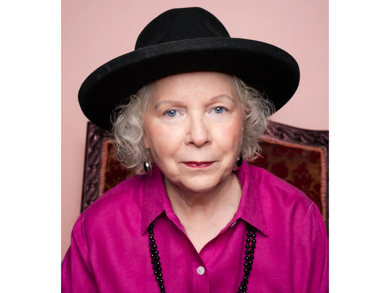 A woman sitting on a chair looking straight ahead