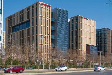 Large-format terracotta panels in earth tones on the HaiKai Park office facade in Beijing
