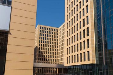 Terracotta panels and vertical baguettes beside glass curtain walling at HaiKai Park, Beijing