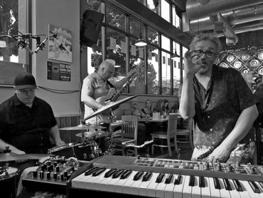 A lively band performing in a cozy cafe with attentive audience.