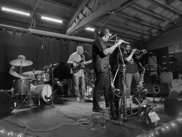 A jazz band performs on stage under blue lighting.