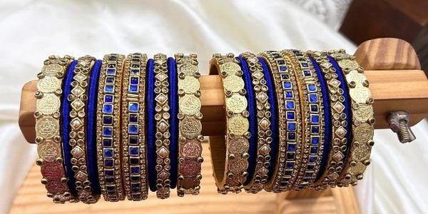 Elegant royal blue silk thread bangles adorned with antique coin motifs and gold-tone detailing.