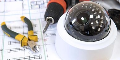 Security camera and tools on architectural blueprints.