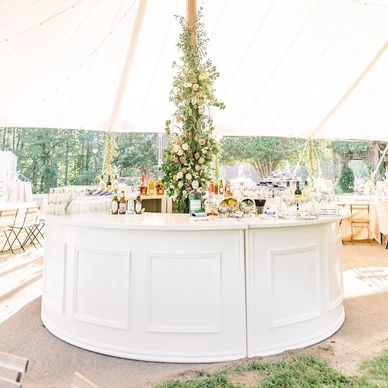 white curved bar under wedding tent