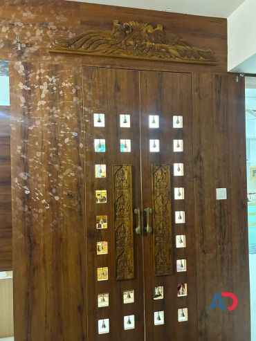 Intricately carved wooden doors with small mirrored squares and hanging bells.