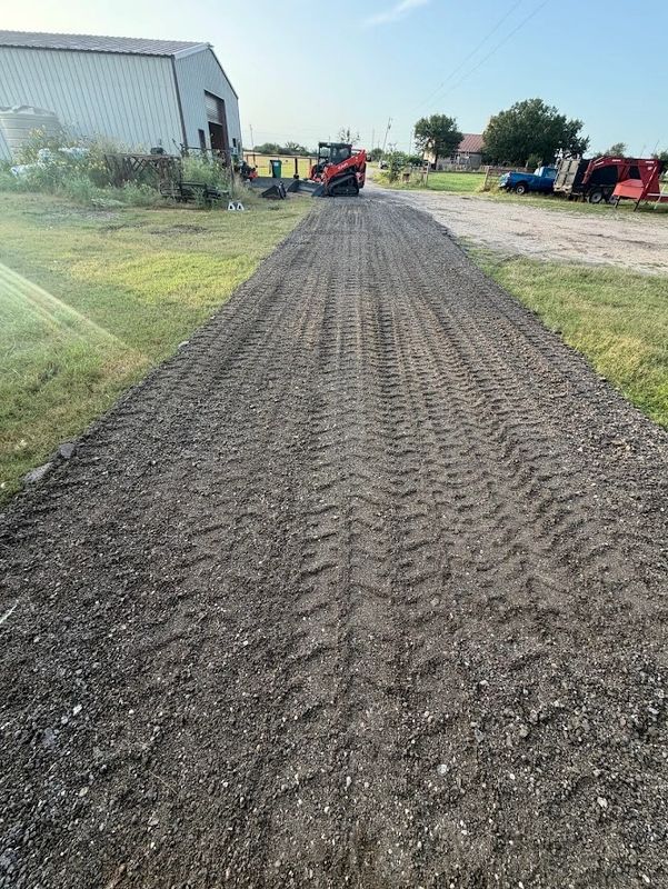 Freshly laid gravel driveway with tire tracks.