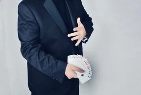A man in a suit showing his cards
