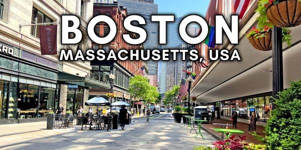 A sunny street scene in Boston, Massachusetts with cafes, flags, and pedestrians.