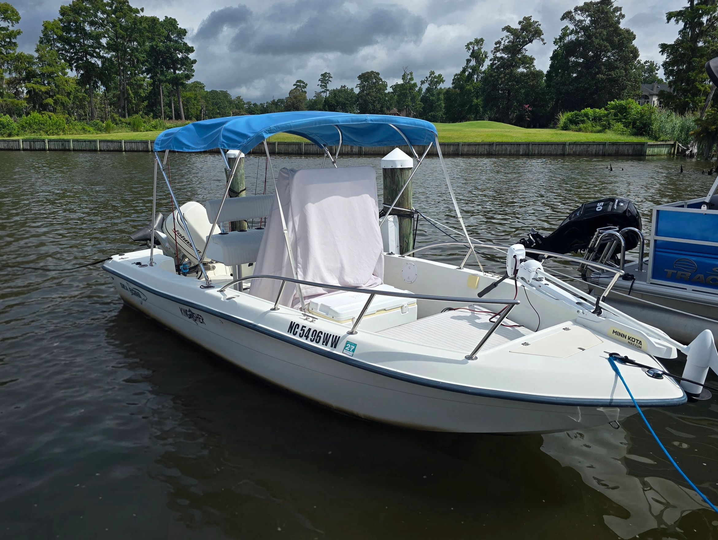 Boat docked by water under a cloudy sky