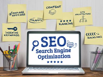 Sticky notes highlight key SEO elements around a laptop.