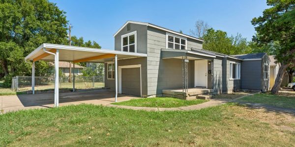 Two-story gray house with carport and front porch.