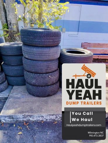Stacked used tires outdoors with a Haul Yeah Dump Trailers advertisement overlay.