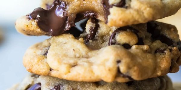 Close-up of gooey chocolate chip cookies stacked together.