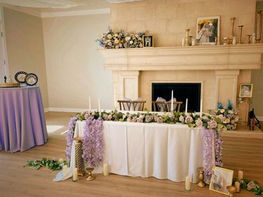 Sweetheart table with taper candles, lavendar wisteria, and gold accents. Location Sleepy Ridge Venu