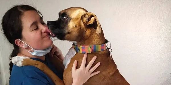 Una doctora recibiendo besos de un paciente feliz