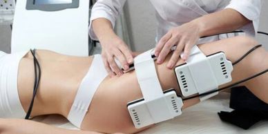 Practitioner undertaking a Fat Cavitation session using laser Lipo being done the thighs of a female