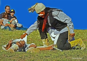 A family watches as a young Apache warriors perform the Deer Hunt dance