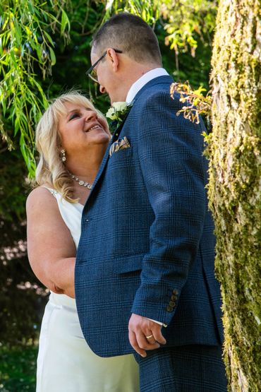 Bride and groom share a tender moment outdoors on their wedding day.