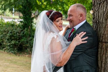 Bride and groom embracing outdoors on their wedding day.