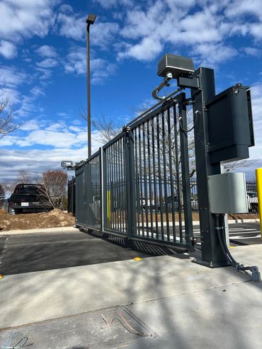 Automated security gate with sensors under a blue sky.
