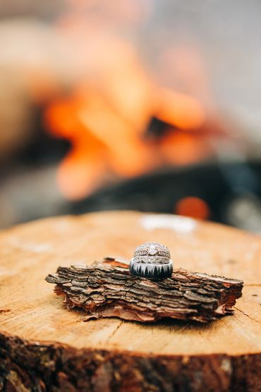Wedding detail images on rings in front of fire pit Northern Arizona