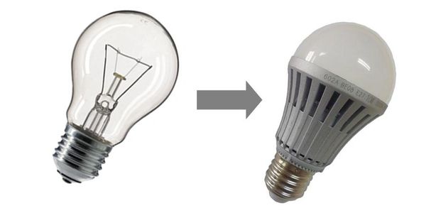 An electrician repacing an incandescent light bulb to a LED light bulb.
