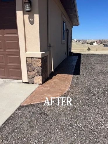 New stamped concrete pathway added beside a house in a dry landscape.
