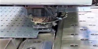 Close up of a CNC punching machine working on aluminium sheet.