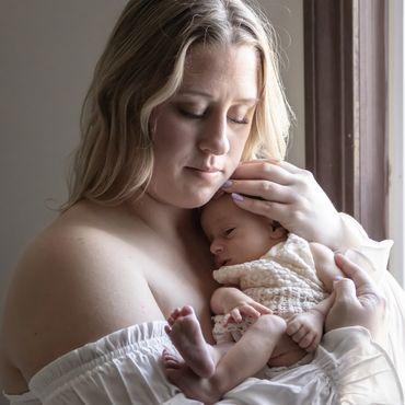 Mommy holding baby during newborn in home session with Living Life Photography