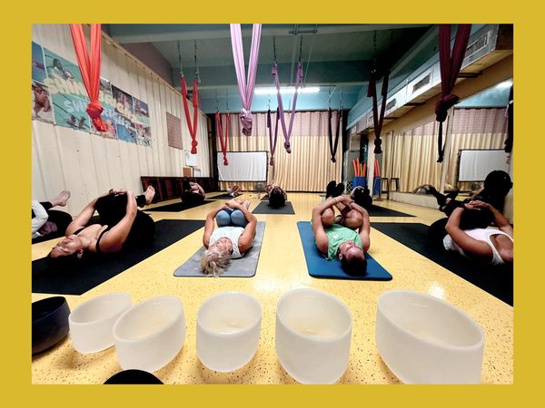 Group yoga session with crystal singing bowls in a studio.