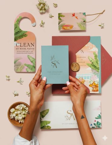 Elegant tropical-themed wedding stationery set with hands holding an itinerary card.