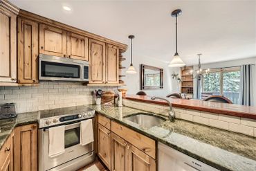 Rustic kitchen with wooden cabinets and stainless steel appliances.