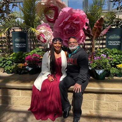 Couple smiling in front of large floral decorations at Creation Museum.