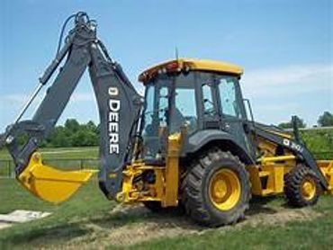 A yellow and black tractor is parked in the grass.