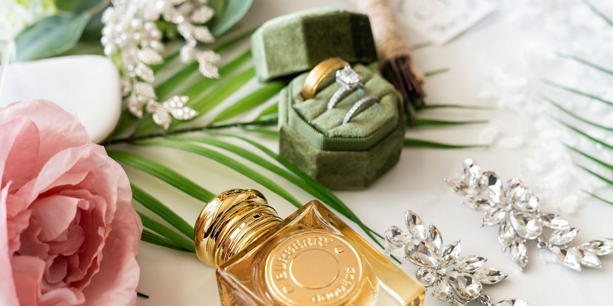 Wedding accessories including rings, perfume, earrings, and flowers.