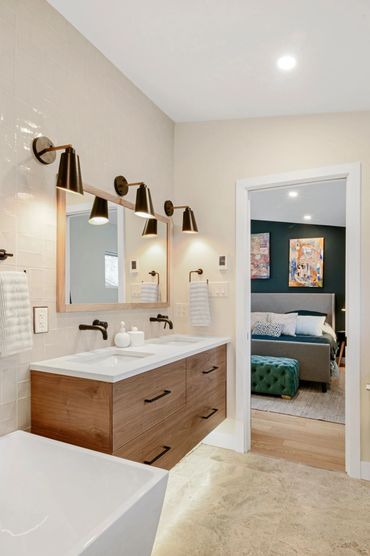 Modern bathroom with double sink vanity and view into bedroom.