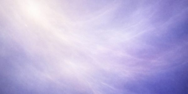 Soft light rays shining through a purple-hued misty atmosphere.