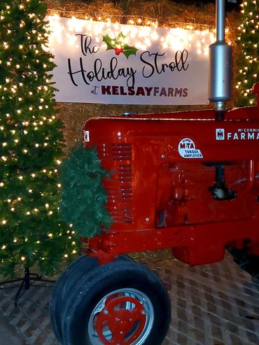 Festively decorated red tractor at Kelsay Farms Holiday Stroll event.