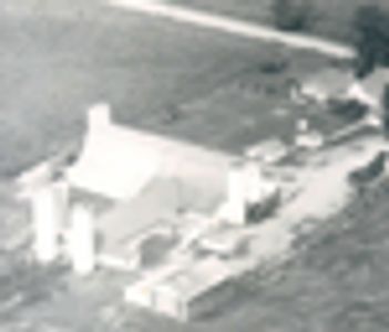 Aerial view of a small rural farm with buildings and vehicles.