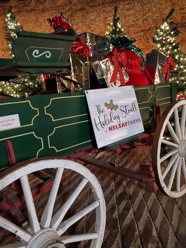 Festive green wagon filled with wrapped holiday gifts at Kelsay Farms.