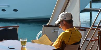 Man reading and relaxing on aft deck on Bonaparte yacht charter