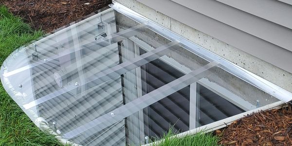 Clear custom window well covers. polycarbonate and aluminum custom window well covers.