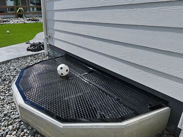 Metal window well cover powder coated with a soccer ball