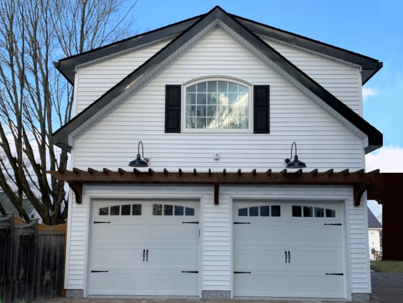 A cottage style garage with upper story.