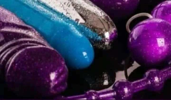 Close-up of colorful adult toys in purple, blue, and silver.